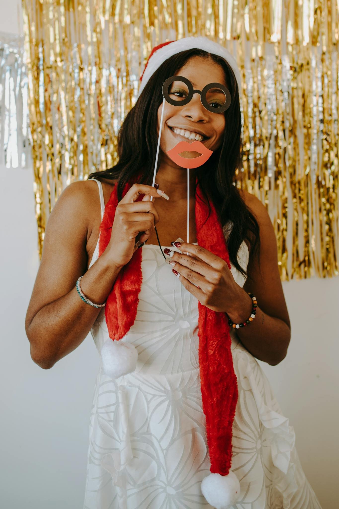 Black woman in festive attire with props at a Christmas party, celebrating with a cheerful spirit.
